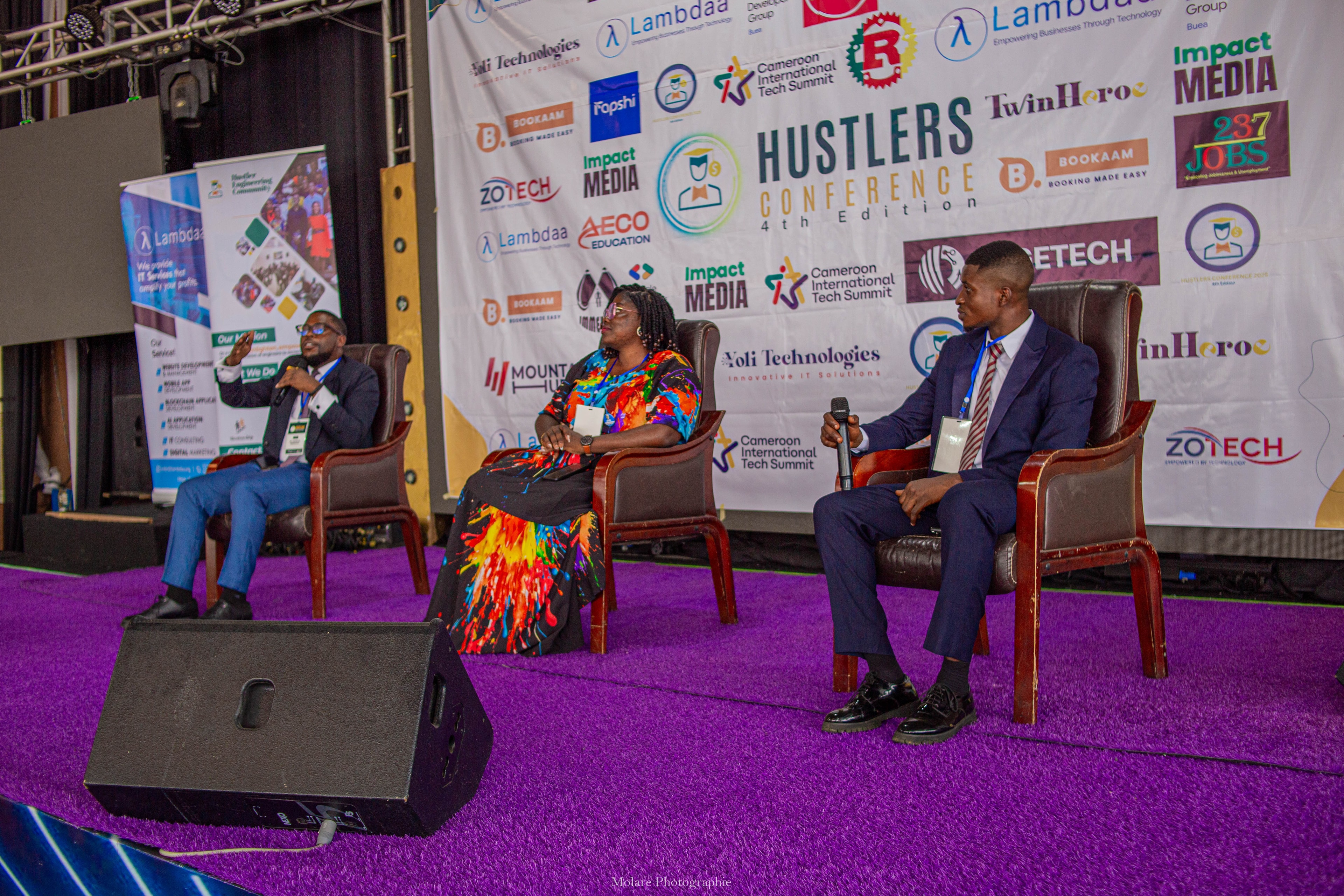 Three panellists in discussion on stage at a past edition.